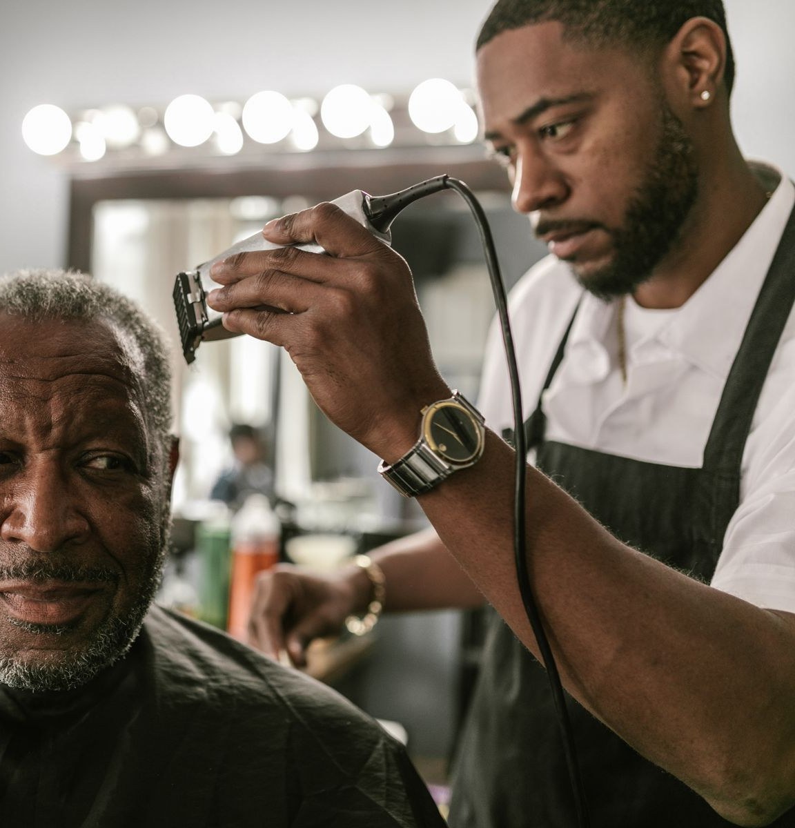 Hairdresser trimming a man's hair with clippers